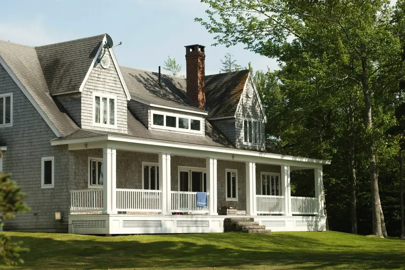 A white and brown wooden house among green trees